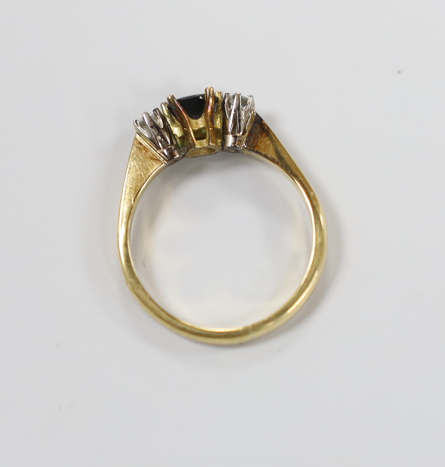 A modern 18ct gold, sapphire and diamond set three stone ring, size L, gross weight 2.7 grams.